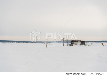 Abandoned building on the background of a snowy field. Abandoned building on the background of a snowy field. 74849575