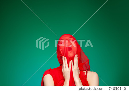 Suffering woman with red cloth on face Suffering woman with red cloth on face 74850140