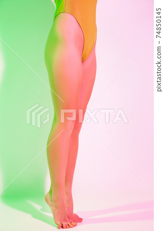 Slim barefoot female in bodysuit in studio Slim barefoot female in bodysuit in studio 74850145