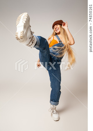 Cheerful trendy female youngster dancing in studio Cheerful trendy female youngster dancing in studio 74850161