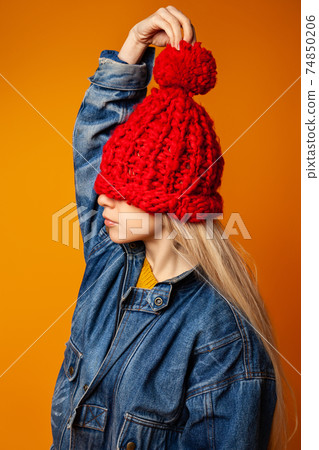 Trendy female teenager in red knitted hat Trendy female teenager in red knitted hat 74850206
