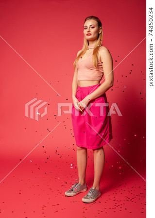 Stylish woman in pink apparel with confetti Stylish woman in pink apparel with confetti 74850234