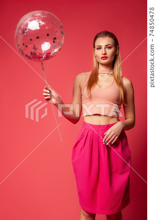 Glamorous woman in pink outfit with balloon Glamorous woman in pink outfit with balloon 74850478