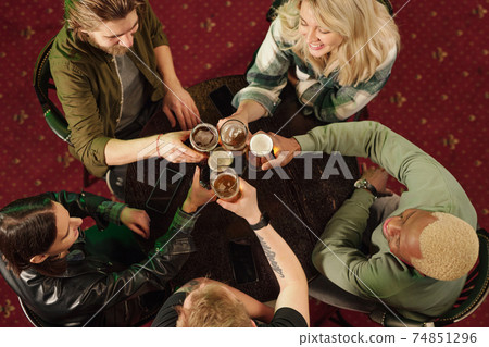 Friends toasting with beer in the bar Friends toasting with beer in the bar 74851296