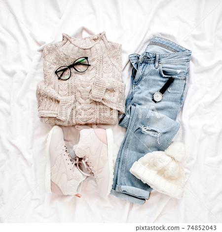 Woman clothes and accessories set on white background. Women's warm sweater, jeans, sneakers. Modern and outfit. Shopping concept. Flat lay, top view. 74852043
