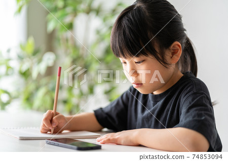 Elementary school girl studying on a smartphone 74853094