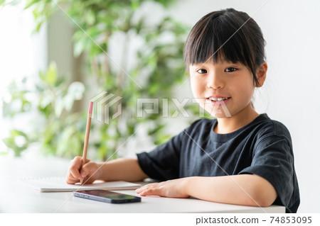 Elementary school girl studying on a smartphone 74853095