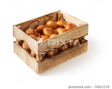Side view of wooden crate with raw yellow onions isolated on white background.  74853178