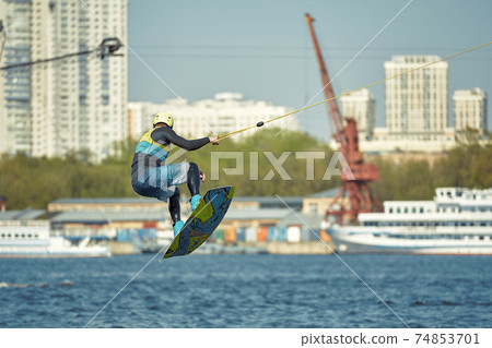 the guy is riding a wakeboard on the river. Active and Extreme Sports 74853701