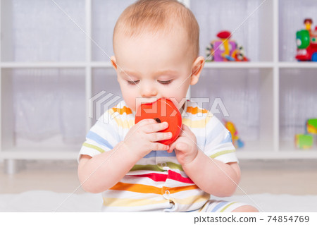 Caucasian baby boy playing with wooden toy. Caucasian baby boy playing with wooden toy. 74854769