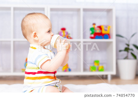 Cute caucasian baby boy drinking from bottle. Cute caucasian baby boy drinking from bottle. 74854770