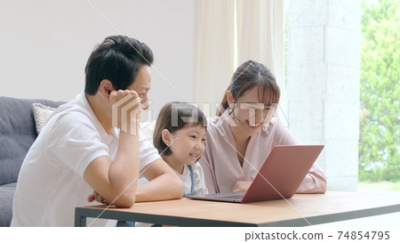 Family looking at a computer Family looking at a computer 74854795