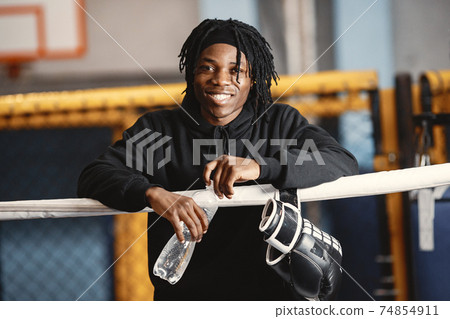 African male boxer in black gloves at the gym 74854911