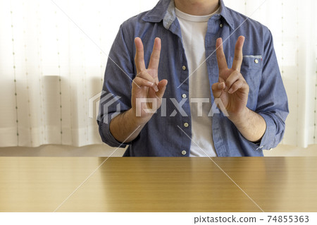 一個男人坐在椅子上，雙手和平（30多歲，日本人，便衣） 74855363