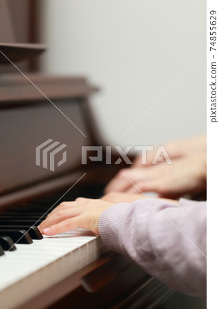 5-year-old girl and mom playing an upright piano 74855629