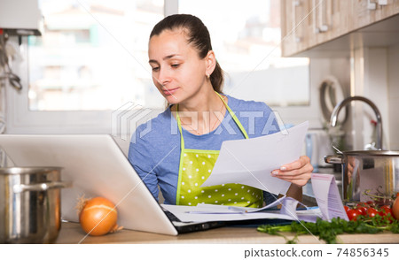 Woman working with papers and laptop 74856345