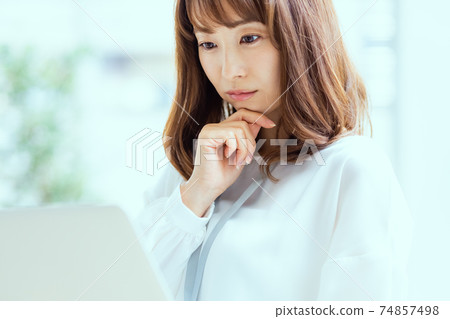 女人看著筆記本電腦的屏幕 74857498