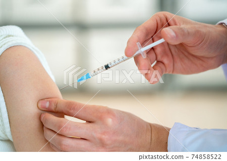 A doctor who vaccinates a patient 74858522