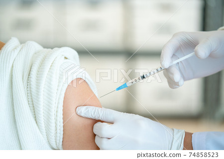 A doctor who vaccinates a patient A doctor who vaccinates a patient 74858523