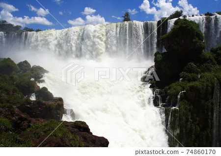 橫跨阿根廷和巴西邊界的伊瓜蘇瀑布（Iguazu Falls）從阿根廷一側的瀑布和藍天 74860170