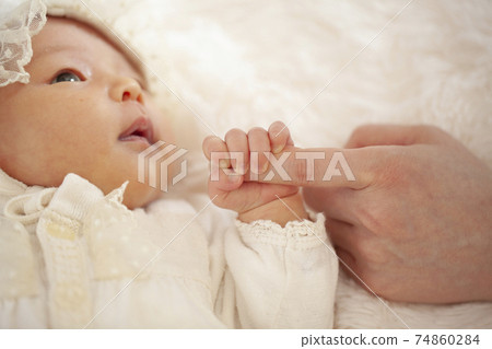 Newborn baby holding mom's finger 74860284