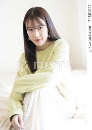 一個美麗的女人，坐在床上的肖像 74861003