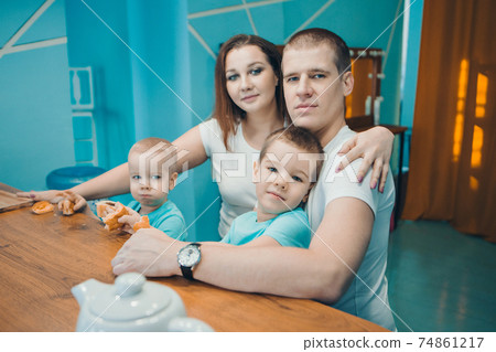 the family eats cakes. dinner at the bakery. feast in the kitchen. the butchering of the food. a woman cuts a pie with a knife the family eats cakes. dinner at the bakery. feast in the kitchen. the butchering of the food. a woman cuts a pie with a knife 74861217