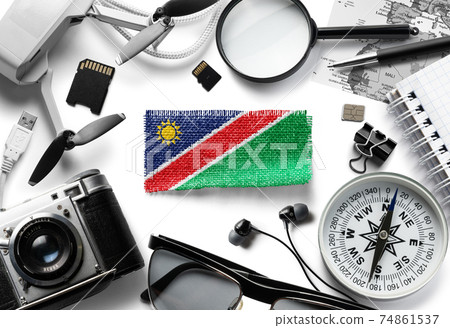 Flag of Namibia and travel accessories on a white background. 74861537