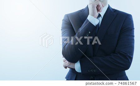 Thinking man in a blue suit. Composition with copy space seen from the front. Backlight and flare. Thinking man in a blue suit. Composition with copy space seen from the front. Backlight and flare. 74861567