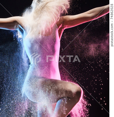 Girl in color dust cloud posing in studio Girl in color dust cloud posing in studio 74862028