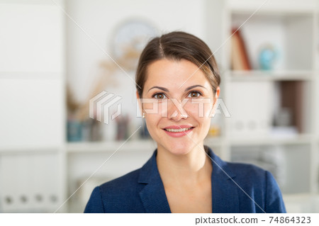 Portrait of young smiling businesswoman in modern office Portrait of young smiling businesswoman in modern office 74864323