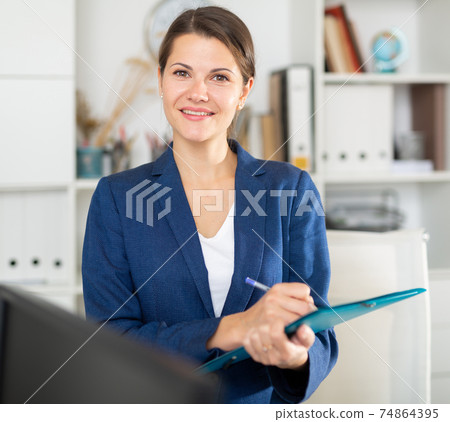 Female office worker is standing with documents before signing 74864395