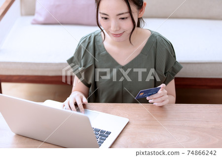 A young woman who enjoys online shopping at home 74866242