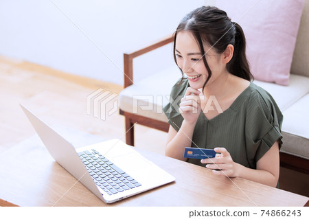 A young woman who enjoys online shopping at home 74866243