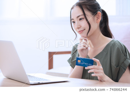 A young woman who enjoys online shopping at home 74866244