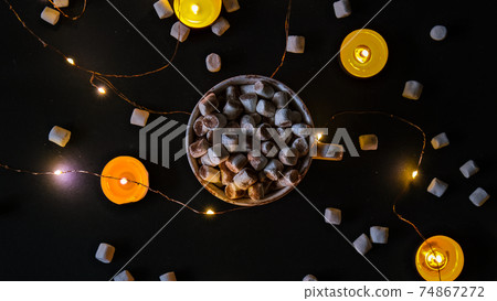 Cup with hot winter cacao and marshmallows at night. Christmas lights. Tea light candles. Good night sweet dreams. Cup with hot winter cacao and marshmallows at night. Christmas lights. Tea light candles. Good night sweet dreams. 74867272