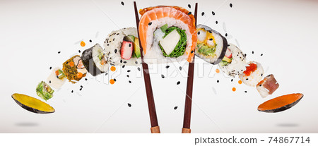 Pieces of delicious japanese sushi frozen in the air. Pieces of delicious japanese sushi frozen in the air. 74867714