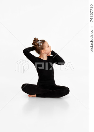 child girl in black sportswear doing stretching. child girl in black sportswear doing stretching. 74867750