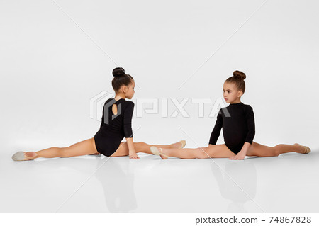 two gymnast girls performs gymnastic poses 74867828