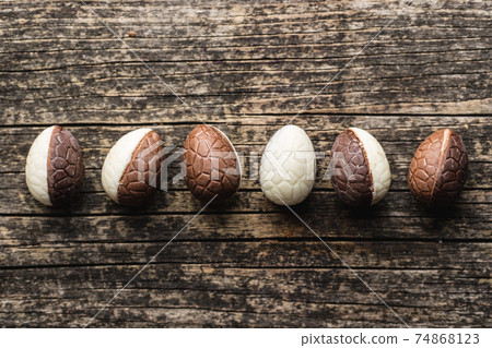 Chocolate easter eggs. Sweet candy eggs on wooden table. 74868123
