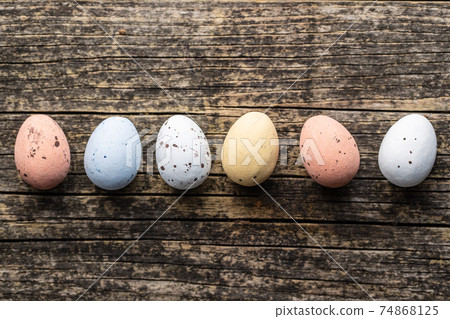 Colorful chocolate easter eggs. Sweet candy eggs on wooden table. 74868125