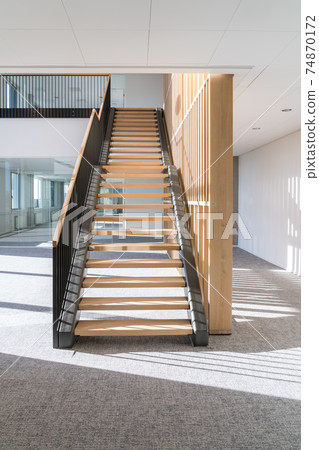 This beautiful wooden staircase is located in the middle of a large building 74870172