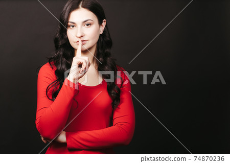 Pretty young girl showing silence gesture Pretty young girl showing silence gesture 74870236