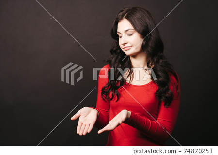 Doubtful confused woman with cupped hands 74870251
