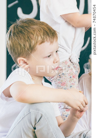 The little boy in white t-shirt looks away The little boy in white t-shirt looks away 74870454