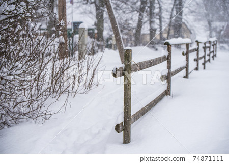 Wooden fence in the snow on winter country background Wooden fence in the snow on winter country background 74871111
