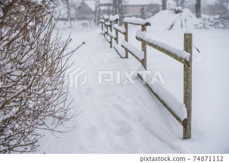 Wooden fence in the snow on winter country background Wooden fence in the snow on winter country background 74871112