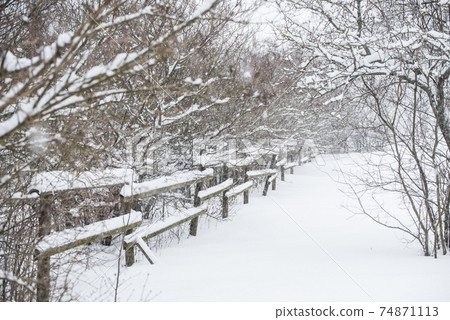 Wooden fence in the snow on winter country background Wooden fence in the snow on winter country background 74871113