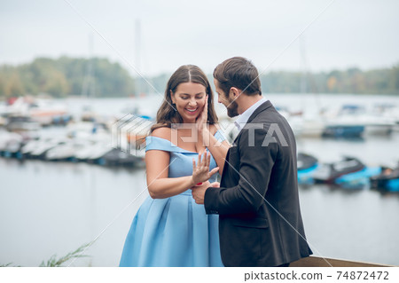 Delighted woman and pleased man during engagement 74872472