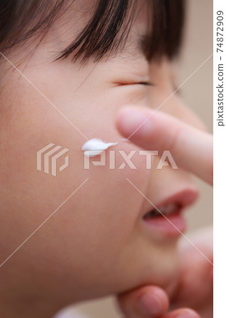 媽媽的手指給孩子塗藥膏 74872909